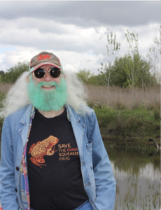 Man with long white hair and a green beard.